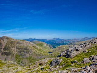 View of Broadcrag Tarn surrounded by rocky mountains from high above (Scafell Pike, Lake District, England, United Kingdom)