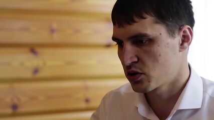 Intense Russian Male Job Applicant in White Shirt During Interview in Wood-Paneled Office