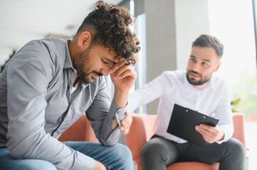 Psychologist comforting upset man during therapy session