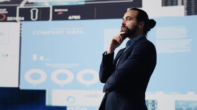 Business analyst reflecting on monthly company results for development strategy, reviewing the complexity of business analysis through finance and forecasting, digital tools. Camera A.