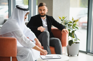 International operations manager discussing contract with saudi business partner