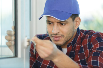a young male worker fixing a window frame