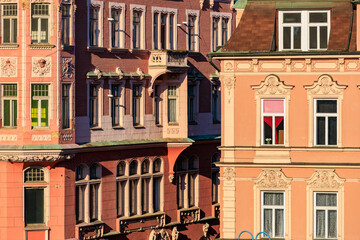 Historic european architecture with pink facades and art nouveau details in sunlight