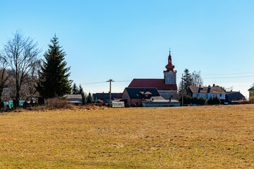 Rural winter village landscape with church and clear blue sky