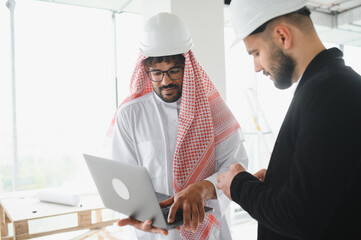 Arab businessman and investor discussing real estate construction project with architect on laptop