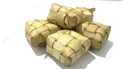 Traditional ketupat woven from young coconut leaves, commonly served during Eid al-Fitr and festive celebrations in Indonesia. Cultural food background.