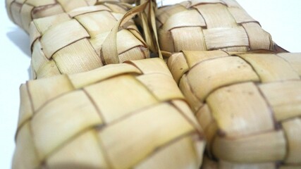 Traditional ketupat woven from young coconut leaves, commonly served during Eid al-Fitr and festive celebrations in Indonesia. Cultural food background.