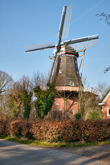 Obraz premium Hulling mill De Vier Winden in Pieterburen with Four Sails under Bright Blue Sky
