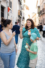 Family enjoying ice cream while walking down a picturesque spanish street
