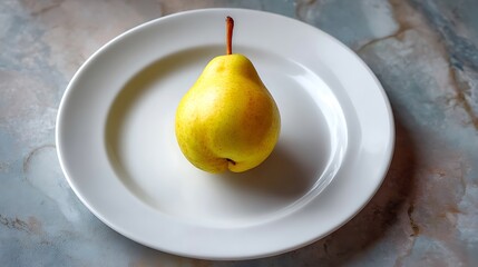 A single yellow pear placed on a white plate against a marble background