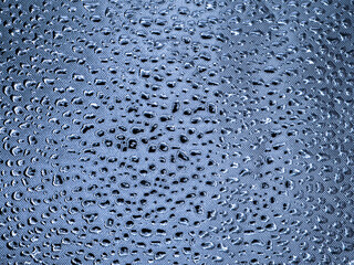 Abstract monochrome metallic blue gray texture. Many dents of various shapes and sizes on a shiny background. Copy space.