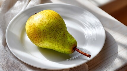 Ripe pear placed on a white plate with natural light