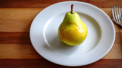 Ripe pear placed on a white plate atop a wooden table