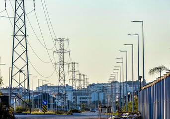 High-voltage power lines stretch into perspective among Manavgat’s urban sprawl, flanked by...