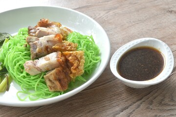 Chinese jade noodles topping roasted crispy pork dipping sweet soy sauce on plate 