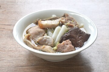 large rice noodles chop and crispy pork topping blood in clear soup on bowl   