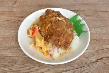 deep fried slice pork with egg or tonkatsu with Japanese pickled vegetable on rice in plate