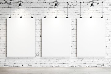 Blank white posters hanging on a white brick wall under black pendant lights.
