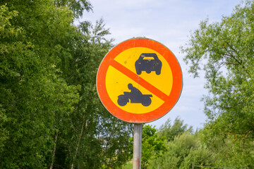 A sign with a prominent warning against the use of vehicles including cars and motorcycles stands...