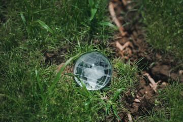 Crystal globe resting on green grass in a tranquil outdoor setting