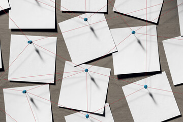 Blank note papers pinned with red threads on wooden wall background symbolizing detective...