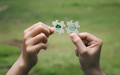 Hands Holding Puzzle Pieces with Green Symbols on Blurred Background