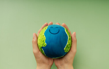 Happy Earth in hands symbolizing sustainability, global happiness, environmental care, and ecological responsibility