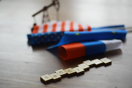 Sanctions Concept: Flags of USA, Russia, and EU with Oil Pump Silhouette and Scrabble Letters - Powered by Adobe