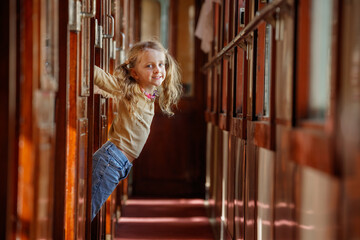 Little girl swings playfully from cabin doorway inside train