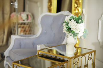 Elegant Living Room with Blue Armchair and Flower Vase on Gold Side Table