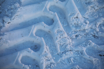 Close-Up of Snowy Tire Tracks in Winter Terrain