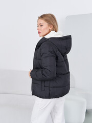 Fashion model showcases stylish outerwear in a studio setting during daylight