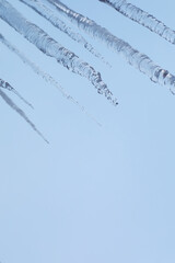 Close-Up Shot of Icicles Against a Clear Blue Sky Perfect for Winter Themes and Seasonal Stock Photography