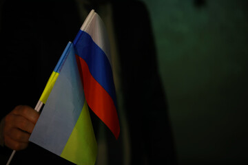 Person Holding Ukrainian and Russian Flags - Symbol of Diplomacy, Conflict, and Tension