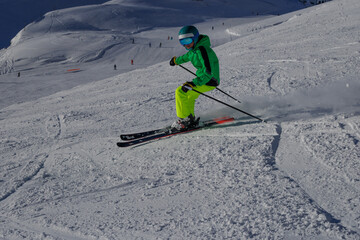 Skier glides past fresh snow on a gentle slope under clear sky
