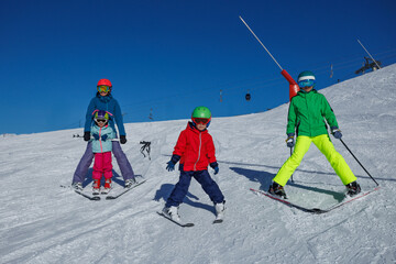 Young skier in red jacket glides down slope under vivid blue sky