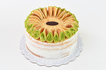 Layered moist cake with white frosting, topped with mini pancakes and piece of chocolate isolated on white background side view of unique dessert