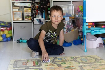 A 7-year-old boy plays with a car in the children's room
