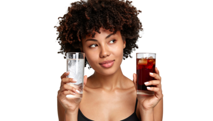 Young Woman Choosing Between Water and Cola