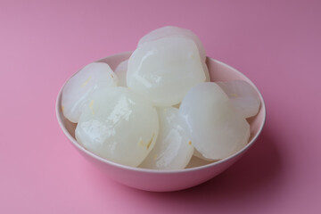 toddy palm fruit in bowl on pink background
