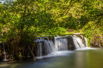 Obraz premium Monte Gelato waterfall surrounded by lush greenery and tranquility in Mazzano Romano, Lazio.