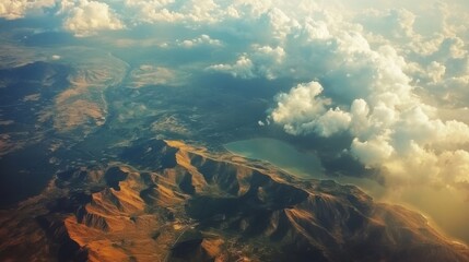 Aerial view of rugged mountain terrain with rolling hills, lush valleys, and dramatic cloud formations, showcasing the beauty of nature and landscape photography