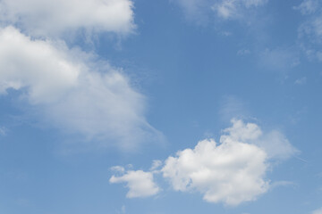 Obraz premium White clouds drifting across a vibrant blue sky on a sunny day
