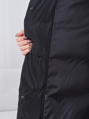 Fashionable model showcasing stylish outerwear in a studio setting during daylight