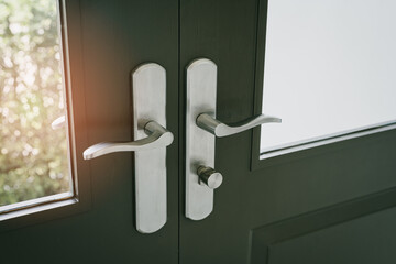 Elegant modern door handles on glass door with natural light illuminating stylish entrance space