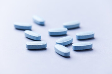 Multivitamin tablets on bright paper background. Close up. Copy space	