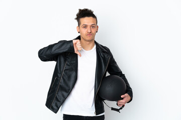 Caucasian man with a motorcycle helmet over isolated white background showing thumb down sign