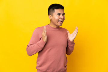 Young Ecuadorian man isolated on yellow background with surprise facial expression