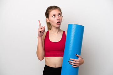 Young sport English woman going to yoga classes while holding a mat isolated on white background...