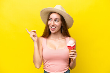 Young caucasian with a cornet ice cream isolated on yellow background intending to realizes the...